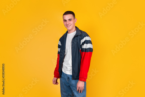 A handsome guy in the style of the 90s on a yellow background © Valeriia