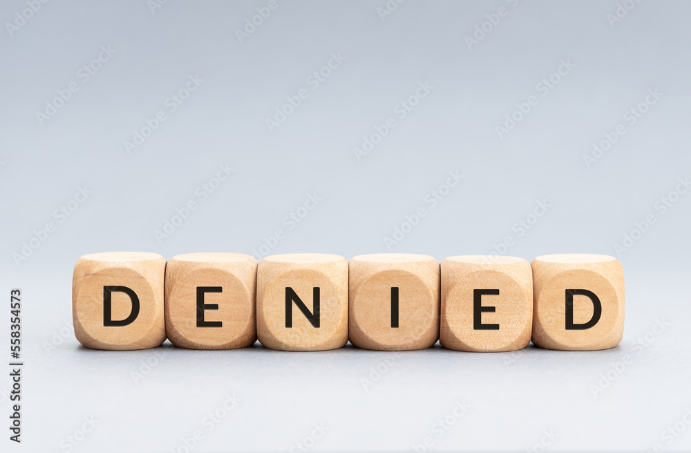 Denied word on wooden blocks on gray background. Copy space Denied word on wooden blocks on gray background. Copy space