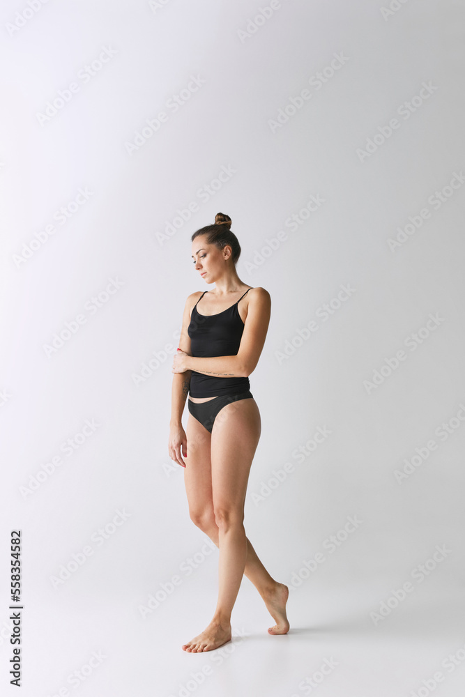 Full-length portrait of slim, beautiful mature woman posing in black  underwear over grey studio background. Slim body shape foto de Stock |  Adobe Stock