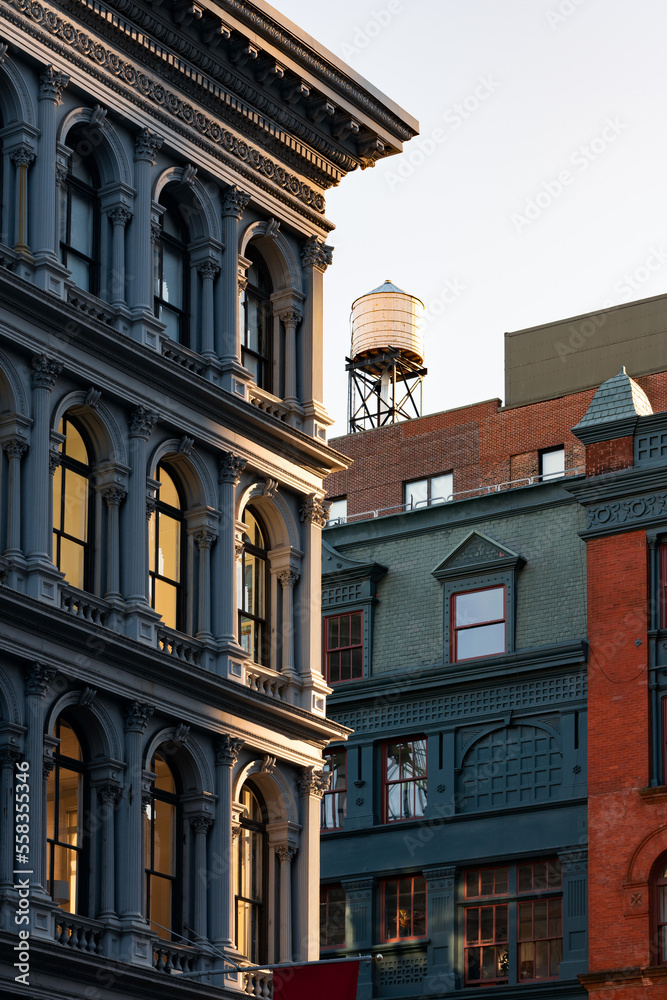 Cast iron facade of Soho loft building and rooftop water tower along Broadway. Soho Cast Iron Building Historic District, Lower Manhattan, New York City