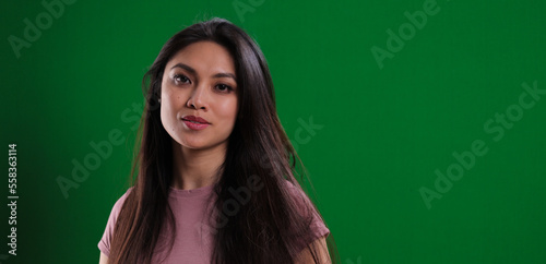 Young pretty woman in the studio posing against a green background - studio photography