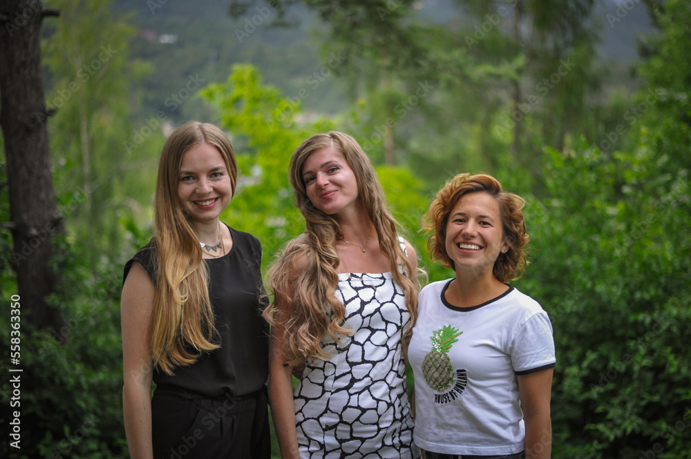 charming cute smiling girl friends with an open, honest faces and wide smiles against a forest in a soft light charming cute smiling girl friends with an open, honest faces and wide smiles against a forest in a soft light