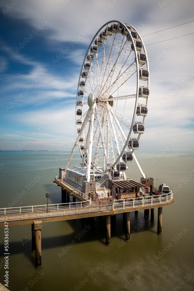 ferris wheel at de pier in den haag netherlands with blue cloudy sky