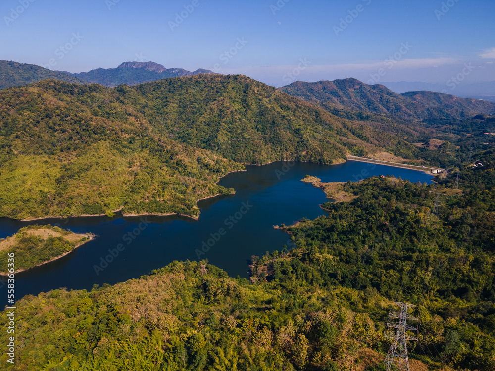 the aerial view of the mountain peak and the cliffs near the green forest