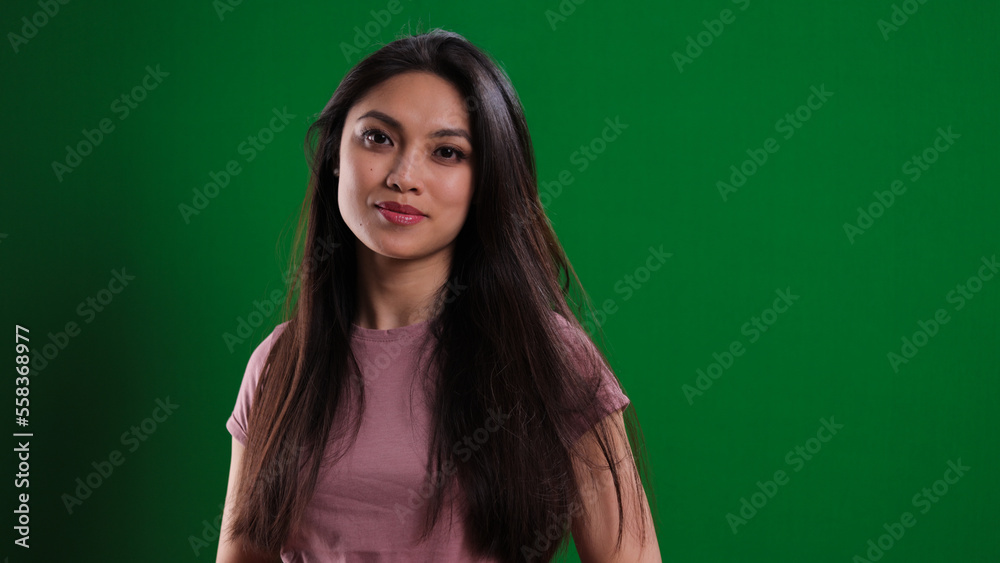 Young confident woman against a green background - studio photography Young confident woman against a green background - studio photography