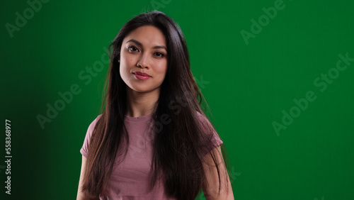 Young confident woman against a green background - studio photography