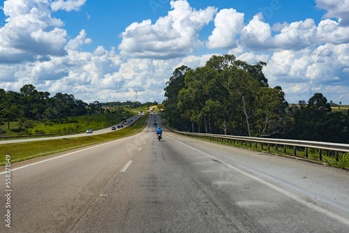a person riding a motorcycle on the road in the countryside with a beautiful scenery in the background