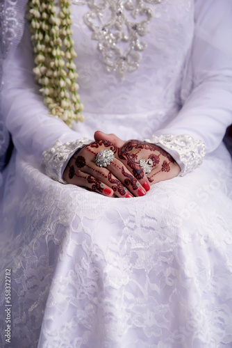 Hands of a woman wearing henna during a wedding procession.