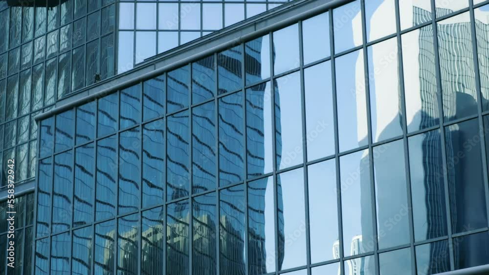 Abstract modern business architecture. Walls made of glass and steel with reflections of buildings and blue sky. Abstract modern business architecture. Walls made of glass and steel with reflections of buildings and blue sky.