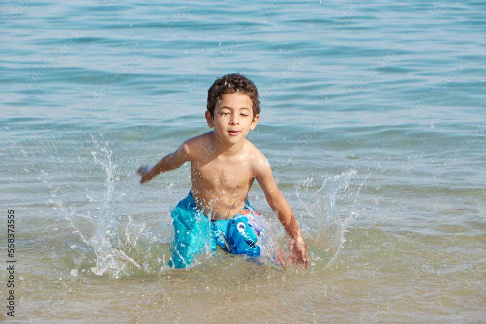 Happy child playing in the sea. Kid having fun outdoors. Summer vacation and healthy lifestyle concept. Happy child playing in the sea. Kid having fun outdoors. Summer vacation and healthy lifestyle concept.