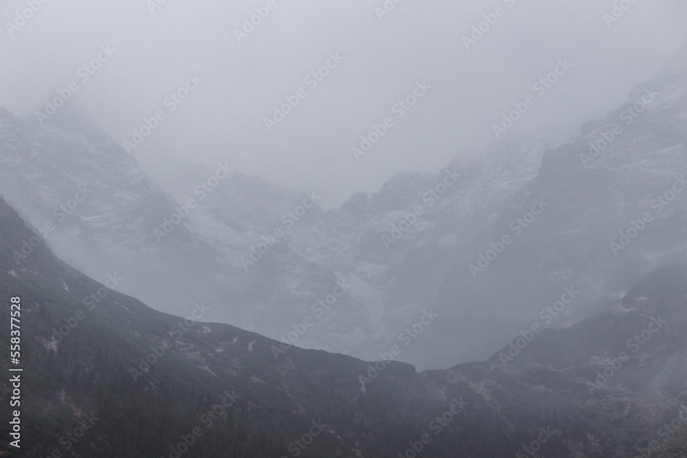 misty mountain landscape with lake, snow and fog