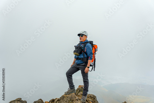 man hiker with backpack in front of a mountain