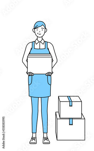 段ボールを運ぶ作業をするエプロンを着たシニア女性