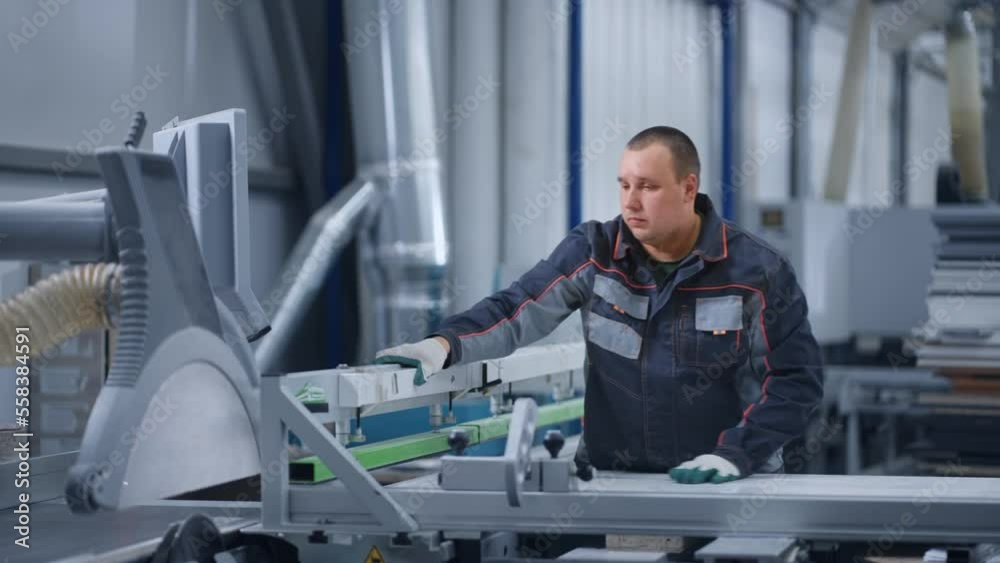 operator of modern CNC machine for cutting and sawing boards in furniture plant, skilled workman operator of modern CNC machine for cutting and sawing boards in furniture plant, skilled workman