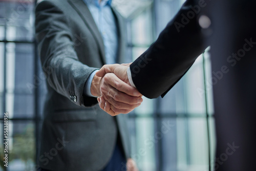 Two diverse professional business men executive leaders shaking hands at office Fototapet