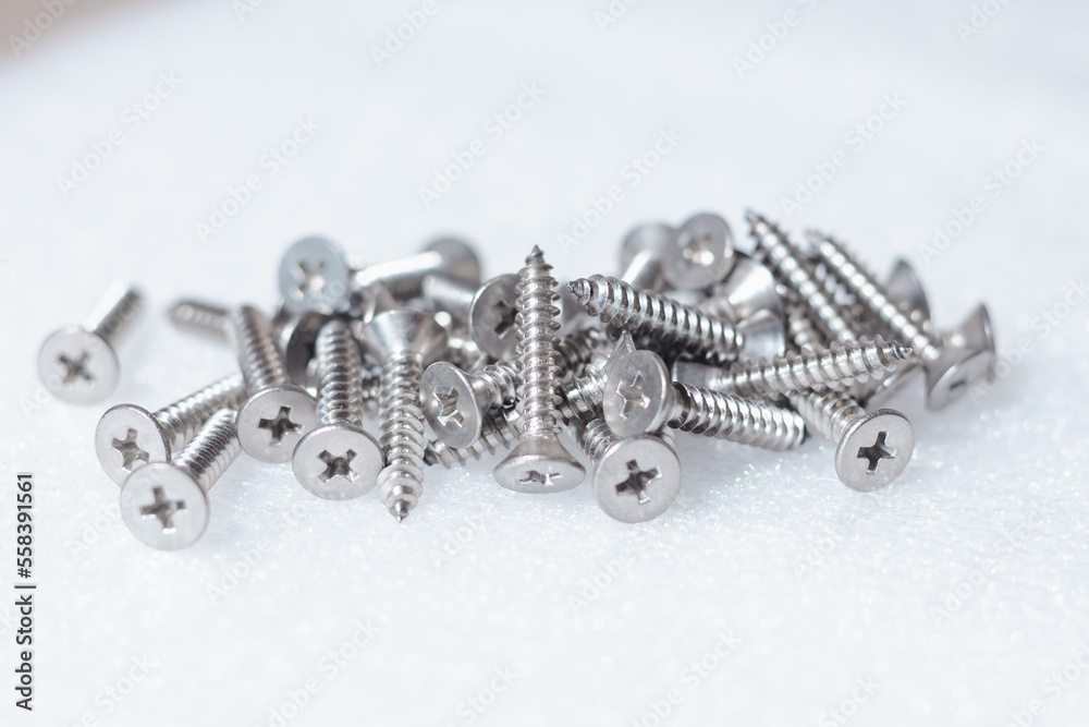 Tapping screws made of steel on table background, metal screw, iron screw, chrome screw, screws as a background, wood screw, concept industry. copy space for text. Tapping screws made of steel on table background, metal screw, iron screw, chrome screw, screws as a background, wood screw, concept industry. copy space for text.