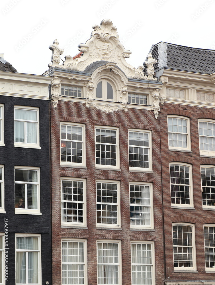 Fototapeta premium Amsterdam Canal House Facade with Sculpted Roof Decoration, Netherlands