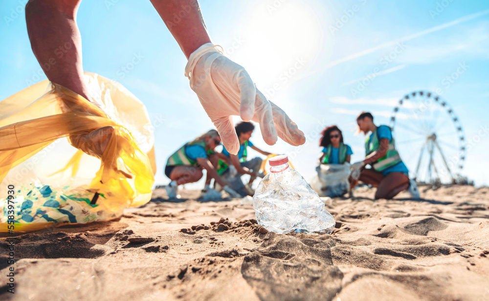 Group of eco volunteers picking up plastic trash on the beach - Activist people collecting garbage protecting the planet - Ocean pollution, environmental conservation and ecology concept - obrazy, fototapety, plakaty 