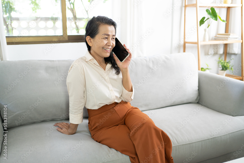 Middle age Asian woman holding cell telephone . smiling Beautiful mature asian woman talking on the smart phone with technology concept Middle age Asian woman holding cell telephone . smiling Beautiful mature asian woman talking on the smart phone with technology concept