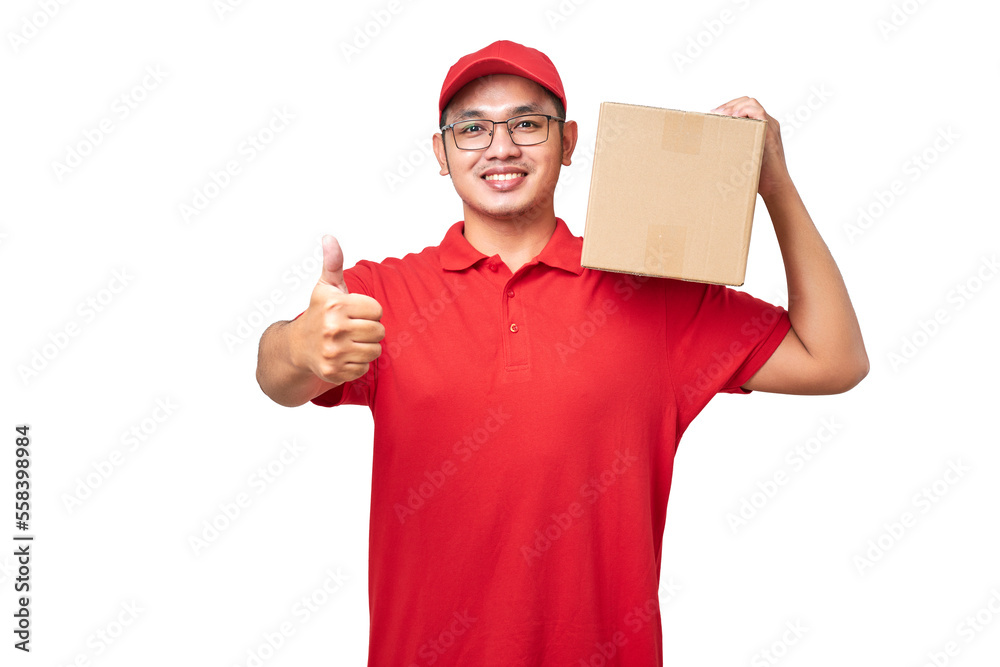 Friendly asian courier delivery man wearing red shirt and cap showing thumb-up, holding box package on shoulder