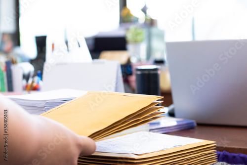 Soft focus of office clerk or secretary is preparing documents and brown envelopes for those interested in bidding for the construction of a large building in an office.