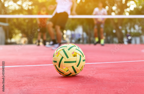 Sepak takraw ball on red floor of outdoor court, blurred background, recreactional activity and outdoor sports in Southeast asian countries concept. photo