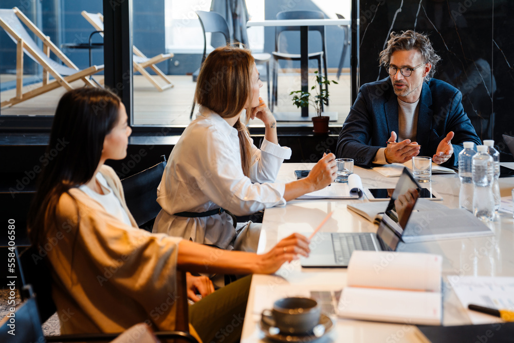 Different age colleagues discussing their project during offline