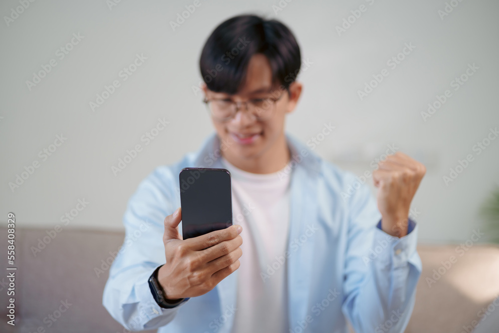 Happy Asian man using smartphone and Excited. Happy Asian man using smartphone and Excited.