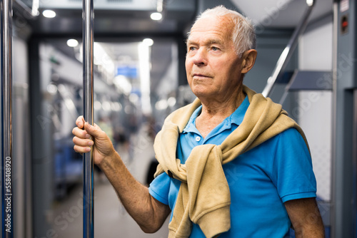 Portrait of mature male passenger riding in subway wagon