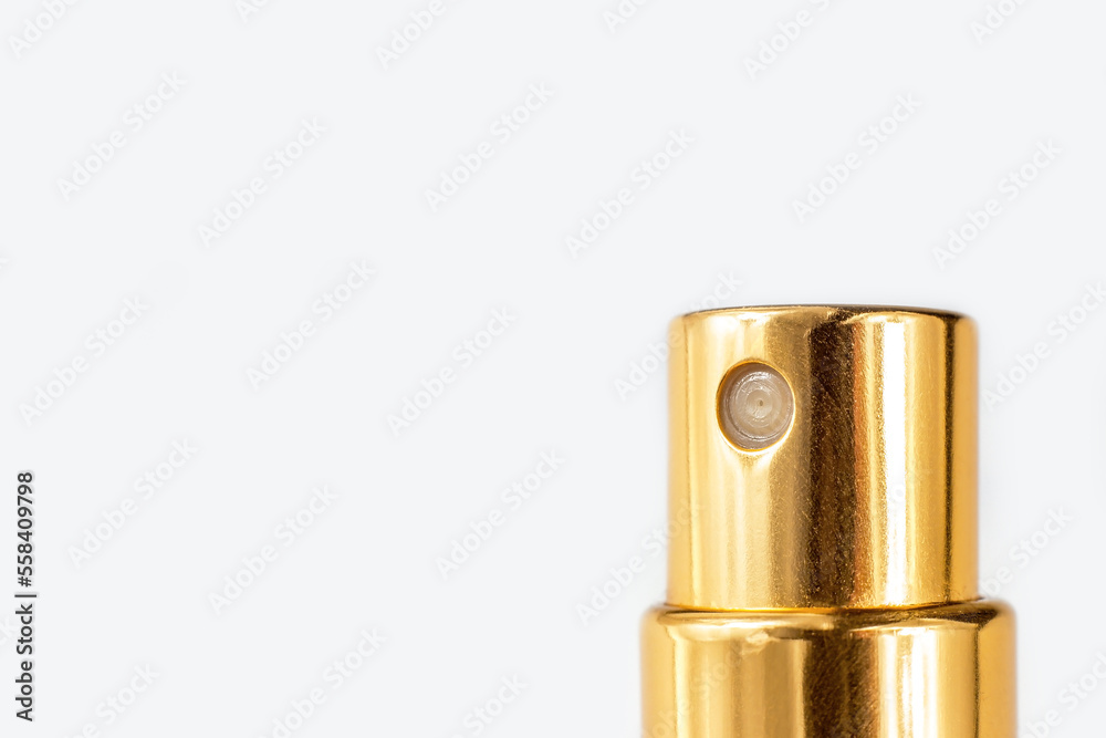 Golden perfume spray cap on light background close up with copy space.