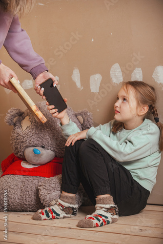 mother takes the schoolgirl's phone from the girl and gives her a book to read, unwillingness to read and learn from children