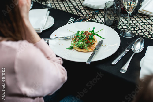 Woman in a restaurant going to eat spicy shrimp tacos with coleslaw and salsa photo