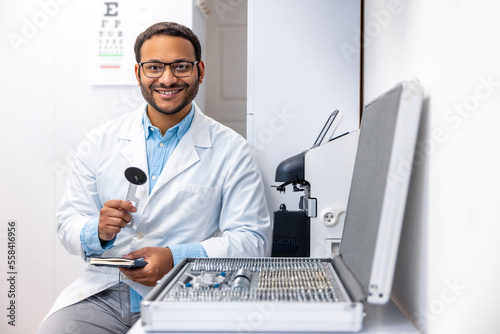 Male doctor in lab coat at his working palce photo