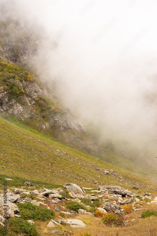 Mountain range with visible silhouettes through the morning colorful fog. Mountain range with visible silhouettes through the morning colorful fog.