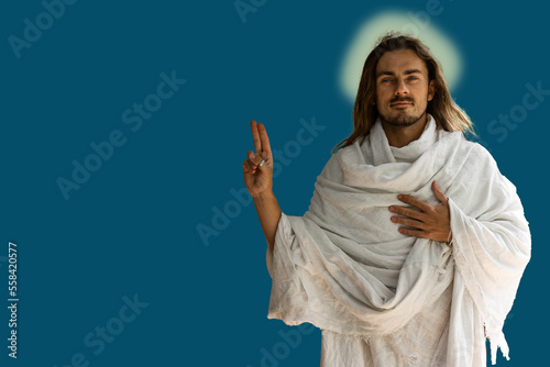 Obraz na płótnie Jesus-type handsome man in white robes against a dark blue background with finger symbol w salonie