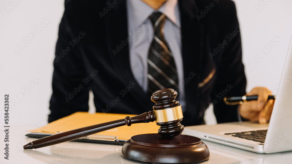 Business and lawyers discussing contract papers with brass scale on desk in office. Law, legal services, advice, justice and law concept. Business and lawyers discussing contract papers with brass scale on desk in office. Law, legal services, advice, justice and law concept.