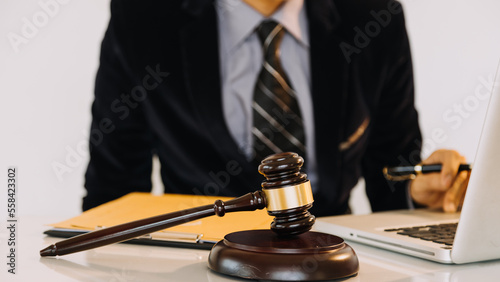 Business and lawyers discussing contract papers with brass scale on desk in office. Law, legal services, advice, justice and law concept.