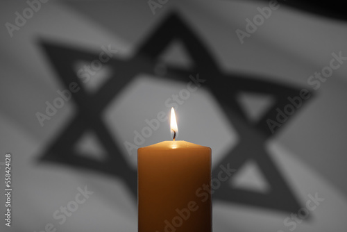 Burning candle on Israel flag background. International Holocaust Remembrance Day, January 27. photo