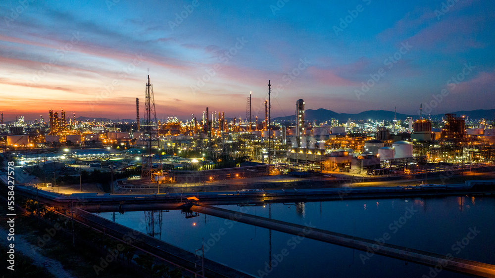 Fototapeta premium Oil and gas refinery plant or petrochemical industry on blue sky sunset background, Factory at twilight time, Gas furnace and smoke stack in petrochemical industrial