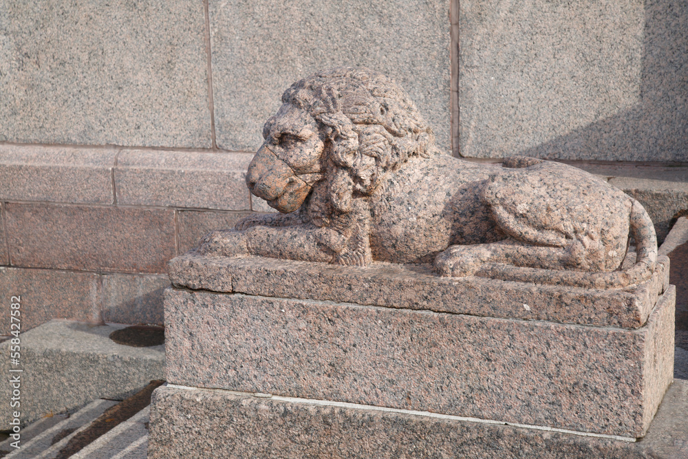 Granite sculpture of a reclining lion outside.