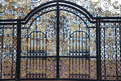 Elegant wrought iron gate with gilded lattice.