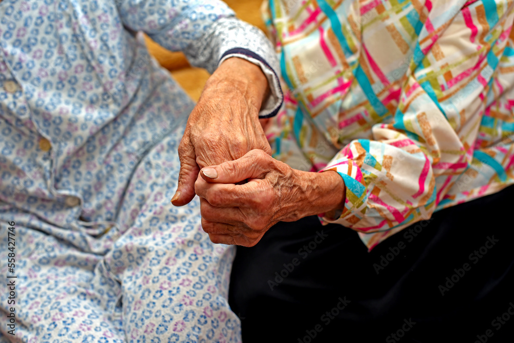 Two elderly women hold hands. No faces. Kharkov, Ukraine