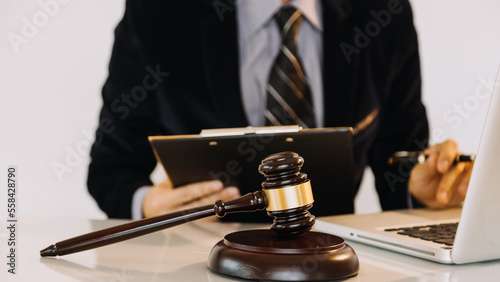 Business and lawyers discussing contract papers with brass scale on desk in office. Law, legal services, advice, justice and law concept.