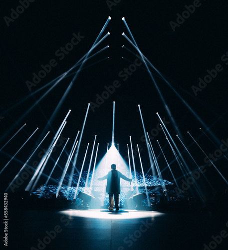 Homme silhouette avec jeux de lumières pour un concert de musique dans une salle en festival de nuit