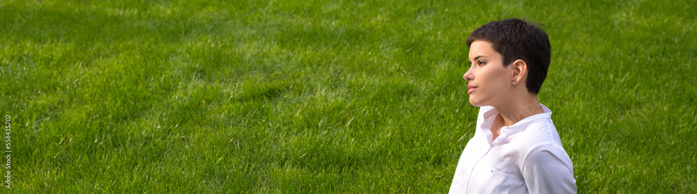 Young woman sitting on the beautiful grass in spring Young woman sitting on the beautiful grass in spring