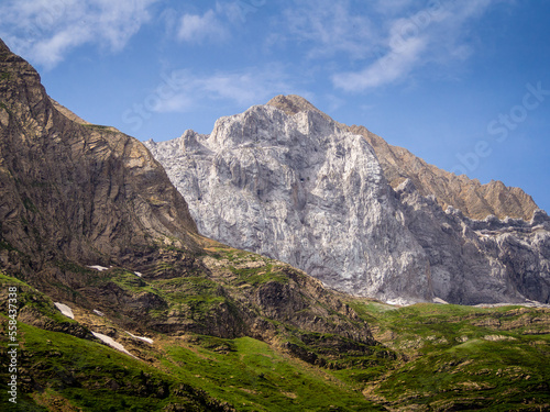 Paisaje alpino con montañas rocosas y cielo azul con nubes blancas photo