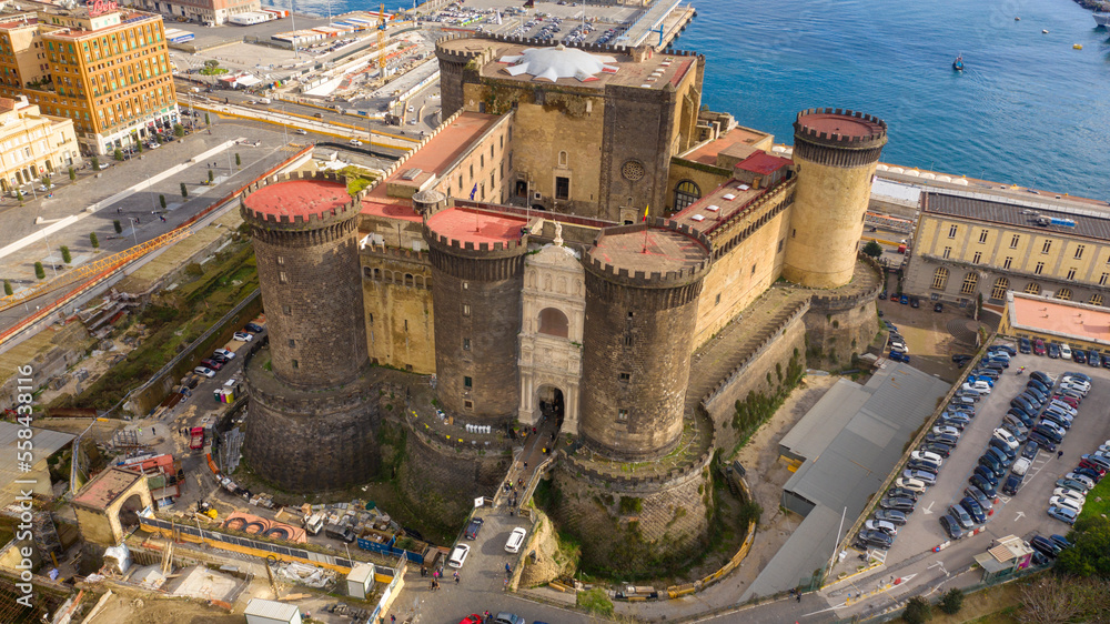 Aerial view of Castel Nuovo often called Maschio Angioino, a medieval castle located on the seafront, in the historic center of Naples, Italy. It was a royal seat for the kings of Naples and Aragon. Aerial view of Castel Nuovo often called Maschio Angioino, a medieval castle located on the seafront, in the historic center of Naples, Italy. It was a royal seat for the kings of Naples and Aragon.