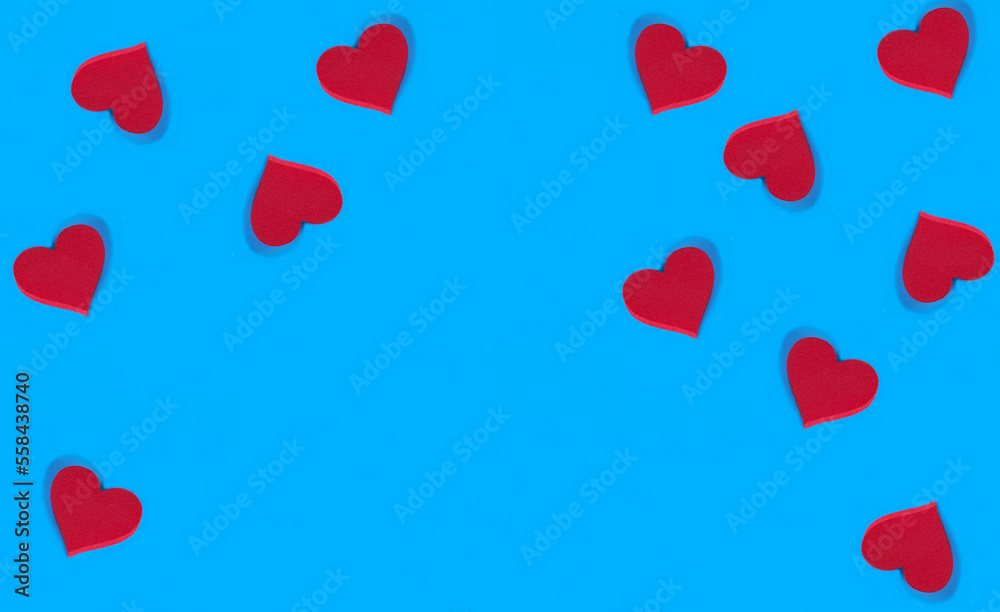 Red hearts on the blue background. Copy space. Holiday background.