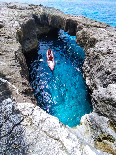 Isola di Paxos, ragazza in kayak tra le scogliere e le grotte marine photo