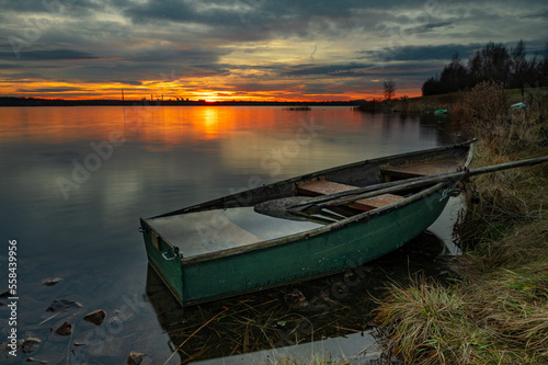 Łódka na tle wschodzącego słońca nad jeziorem Pogoria IV